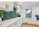 Bright kitchen with white cabinets, green backsplash, and marble countertops at 3200 Ames St, Wheat Ridge, CO 80212