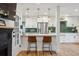 Bright kitchen with stainless steel appliances, white cabinets, and an adjacent breakfast bar at 3200 Ames St, Wheat Ridge, CO 80212