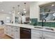 Updated kitchen features white countertops, stainless steel appliances, and green hexagon tile backsplash at 3200 Ames St, Wheat Ridge, CO 80212