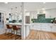 Modern kitchen featuring a breakfast bar, stainless steel appliances, and unique backsplash at 3200 Ames St, Wheat Ridge, CO 80212