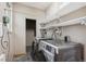Functional laundry room features modern appliances and convenient shelving for storage at 3200 Ames St, Wheat Ridge, CO 80212