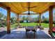 A covered outdoor patio space overlooking a spacious backyard with mature trees at 3200 Ames St, Wheat Ridge, CO 80212