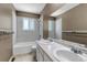 Bright bathroom boasts double vanity, neutral tones, and shower-tub combo at 8696 E Easter Ave, Centennial, CO 80112