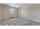 Bedroom boasts neutral tones, plush carpet, a ceiling fan, and a sunlit window at 8696 E Easter Ave, Centennial, CO 80112
