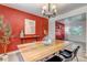 Dining room featuring a wooden table, modern chandelier and a red accent wall with stylish decorations at 8696 E Easter Ave, Centennial, CO 80112