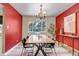 Bright dining room with modern light fixture, beautiful red accent wall and lovely natural light from the window at 8696 E Easter Ave, Centennial, CO 80112