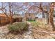 Spacious backyard with mature trees and a stone path leading to the charming brick home at 1741 N Emerson St, Denver, CO 80218