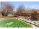 Relaxing backyard with stone patio, lush greenery, and mature trees offering ample shade at 1741 N Emerson St, Denver, CO 80218