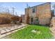 A cozy backyard with mature landscaping, stone patio and brick house at 1741 N Emerson St, Denver, CO 80218