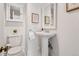 Charming bathroom with pedestal sink, classic toilet, and medicine cabinet storage at 1741 N Emerson St, Denver, CO 80218