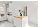 Bright eat-in kitchen with white cabinets, butcher block island, and tiled floors at 1741 N Emerson St, Denver, CO 80218