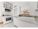 Well-lit kitchen with white cabinetry, stainless steel appliances, tiled floors and granite counters at 1741 N Emerson St, Denver, CO 80218