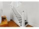 Bright staircase featuring white railings and black treads in a home with wood floors and natural light from an upper window at 1741 N Emerson St, Denver, CO 80218