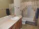 Bright bathroom featuring a vanity sink and shower-tub combo with neutral tile floors at 21024 E 49Th Ave, Denver, CO 80249