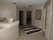 Neutral hallway featuring multiple doorways, a striped rug, and a decorative nook at 21024 E 49Th Ave, Denver, CO 80249