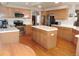 Well-lit kitchen offers stainless steel appliances, wood cabinetry, and a kitchen island with white countertop at 21024 E 49Th Ave, Denver, CO 80249