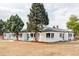 Sprawling white brick home featuring multiple windows, lush landscaping, and meticulous yard maintenance at 4023 E Martin Luther King Jr, Denver, CO 80207
