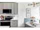 Elegant kitchen featuring gray cabinets, modern appliances, a cozy breakfast nook, and stylish lighting at 4023 E Martin Luther King Jr, Denver, CO 80207