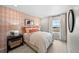 Bedroom featuring a patterned accent wall, and window providing natural light at 6570 Parterre N Pkwy # 1, Thornton, CO 80602