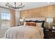 Cozy bedroom with a decorative accent wall, a chandelier, and a large window showcasing the exterior view at 6570 Parterre N Pkwy # 1, Thornton, CO 80602