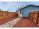 Fenced backyard features a stone walkway leading to the back door of the home at 132 W Bayaud Ave, Denver, CO 80223