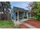 Quaint blue home featuring a charming porch with white pillars, and a well-kept front yard at 132 W Bayaud Ave, Denver, CO 80223