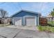 Garage exterior featuring two white garage doors, concrete drive, and exterior siding at 132 W Bayaud Ave, Denver, CO 80223