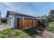 Blue garage exterior featuring two garage doors, wood fence and partial landscaping at 132 W Bayaud Ave, Denver, CO 80223