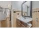Small bathroom boasts a dark vanity and vintage ceramic tiling. Hallway and stairway visible in background at 364 S Ironton St # 425, Aurora, CO 80012