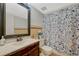 Cozy bathroom features a pedestal sink, vintage ceramic tiling, and shower with blue floral curtain at 364 S Ironton St # 425, Aurora, CO 80012
