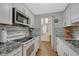 Updated kitchen featuring white cabinetry, granite countertops, subway tile, and modern stainless steel appliances at 364 S Ironton St # 425, Aurora, CO 80012