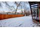 Snow-covered backyard with wooden fence at 1225 Briarhollow Way, Highlands Ranch, CO 80129