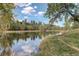 Serene pond reflecting the sky and trees at 23619 Genesee Village Rd # B, Golden, CO 80401