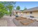 Landscaped backyard with brick patio, garden beds, stone accents, and manicured lawn at 218 E Colorado Ave, Berthoud, CO 80513