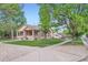Residential street view of a charming brick house with a covered front porch and trees at 218 E Colorado Ave, Berthoud, CO 80513