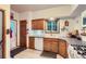 Functional kitchen with wood cabinets, a window over the sink, and tile flooring at 218 E Colorado Ave, Berthoud, CO 80513