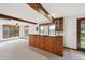 Basement area with a built-in bar, beamed ceilings, multiple windows, and carpeted flooring at 11621 Shoshone Way, Denver, CO 80234