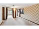 Basement area featuring patterned wallpaper, closet space, neutral carpeting, and an open doorway at 11621 Shoshone Way, Denver, CO 80234
