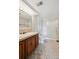 Bathroom with a wood vanity, a sink, a shower with sliding glass doors, and patterned flooring at 11621 Shoshone Way, Denver, CO 80234