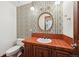 Charming bathroom with colorful wallpaper, a round mirror, and a vanity with tile backsplash at 11621 Shoshone Way, Denver, CO 80234