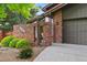 Close-up of the home's front entrance featuring a brick surround, secure gate, and attached garage at 11621 Shoshone Way, Denver, CO 80234
