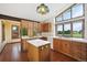 Kitchen with island, oak cabinets, tile floors, and large windows at 11621 Shoshone Way, Denver, CO 80234