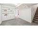 Basement room with built-in shelving and carpeted stairs to upper level at 6188 S Westview St, Littleton, CO 80120