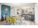 View of dining area with unique lighting adjacent to a modern kitchen with stainless steel appliances at 6188 S Westview St, Littleton, CO 80120