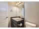 This bathroom has a dark vanity and a large mirror with lots of lighting and neutral-colored walls at 3130 Hardin St, Castle Rock, CO 80109