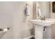Elegant powder room with a pedestal sink, modern fixtures, and neutral wall color at 3130 Hardin St, Castle Rock, CO 80109