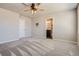 Bright, carpeted bedroom with ceiling fan and access to a well-lit bathroom at 3130 Hardin St, Castle Rock, CO 80109