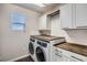Bright laundry room with front loading washer/dryer and butcher block countertops over white shaker cabinets at 3130 Hardin St, Castle Rock, CO 80109