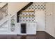 A built-in wet bar under the stairs featuring black and white patterned tile and open wood shelving at 3130 Hardin St, Castle Rock, CO 80109