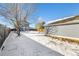 Snowy backyard with detached garage and house view at 2728 Renshaw St, Strasburg, CO 80136